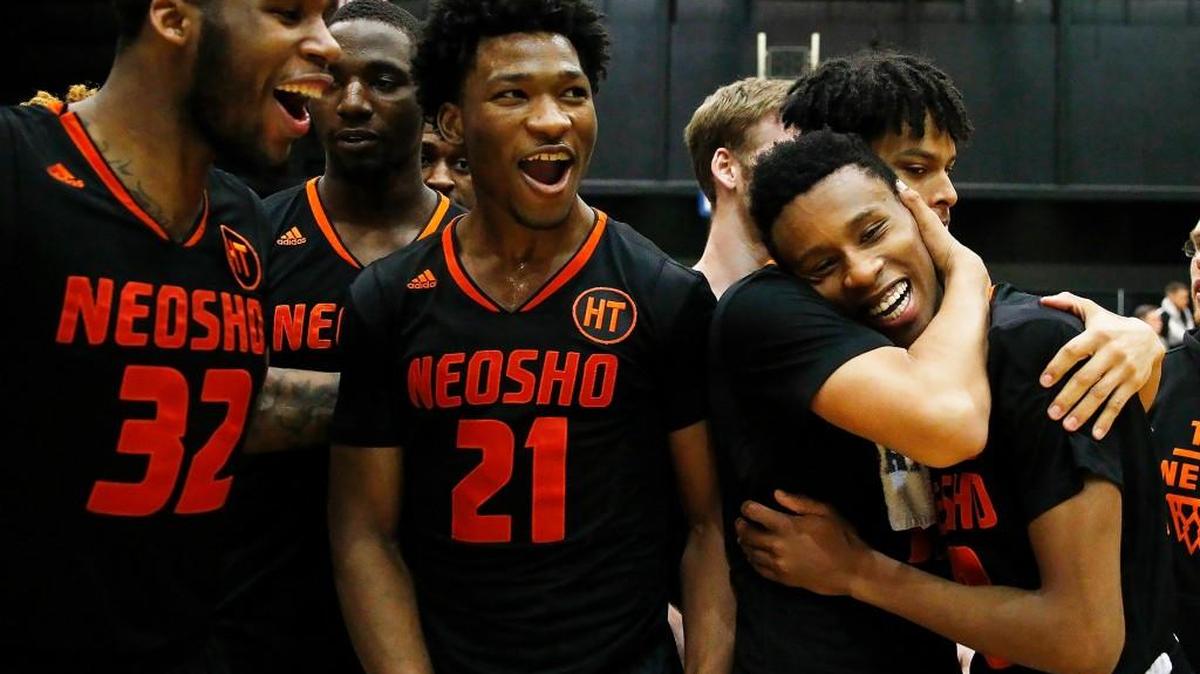 Freddie McSwain (21) celebrates a victory with Neosho County teammates in the NJCAA Region VI final at Hartman Arena.