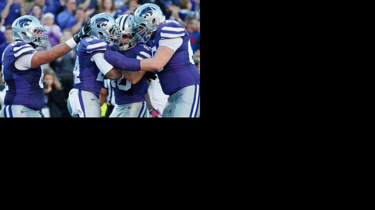 
K-State players celebrate with running back Charles Jones after he scored a second-quarter touchdown on a 11-yard run against Kansas. (Nov. 29, 2014)
