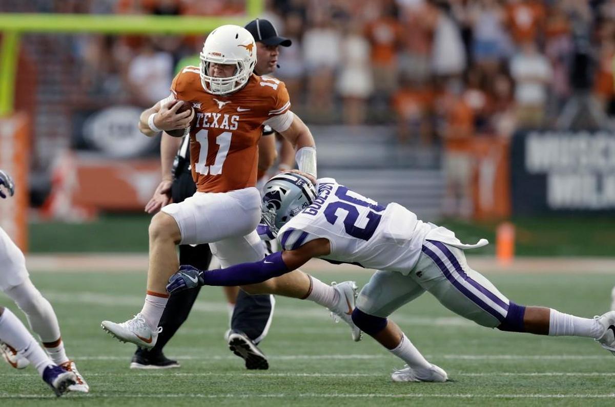 Texas quarterback Sam Ehlinger tries to outrun the tackle of Kansas State defensive back Denzel Goolsby during the first half of an NCAA college football game, Saturday, Oct. 7, 2017, in Austin, Texas.