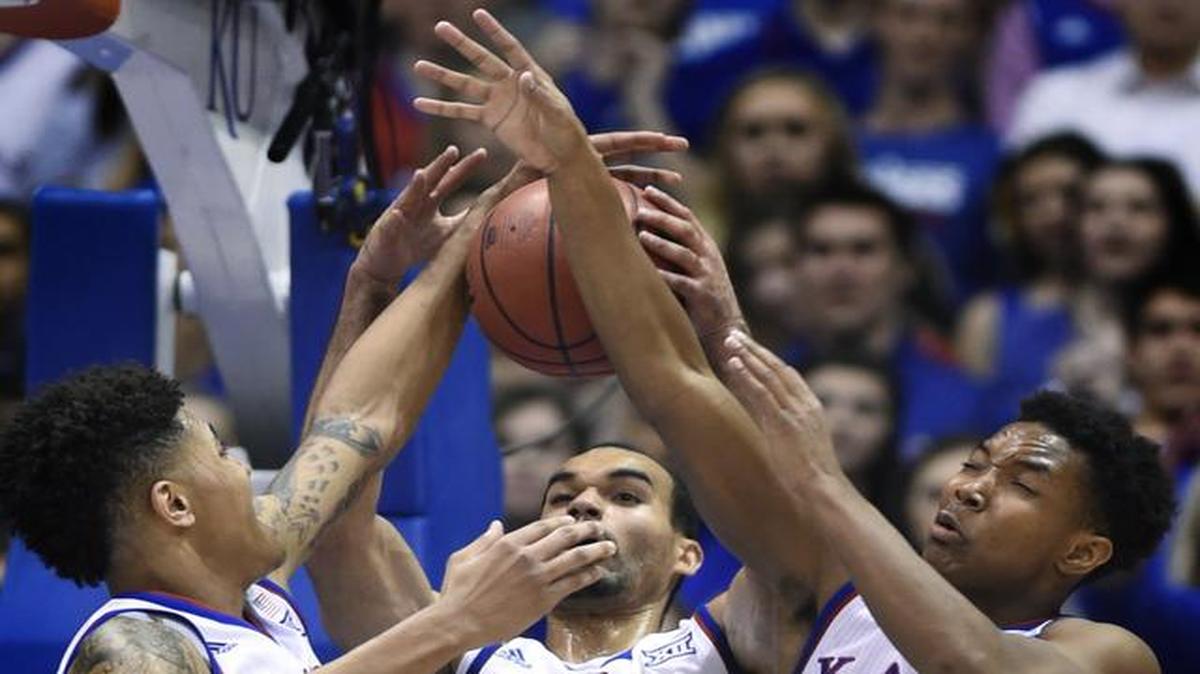 
Kansas' Kelly Oubre, left, Perry Ellis and Devonte Graham surround a rebound during the first half against Kansas State on Saturday at Allen Fieldhouse.
