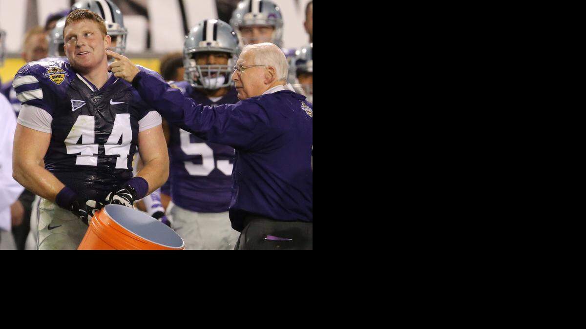 
K-State coach Bill Snyder points out the remaining time on the clock to defensive end Ryan Mueller (44) after Mueller dumped a jug of water onto Snyder near the end of the Buffalo Wild Wings Bowl. 
