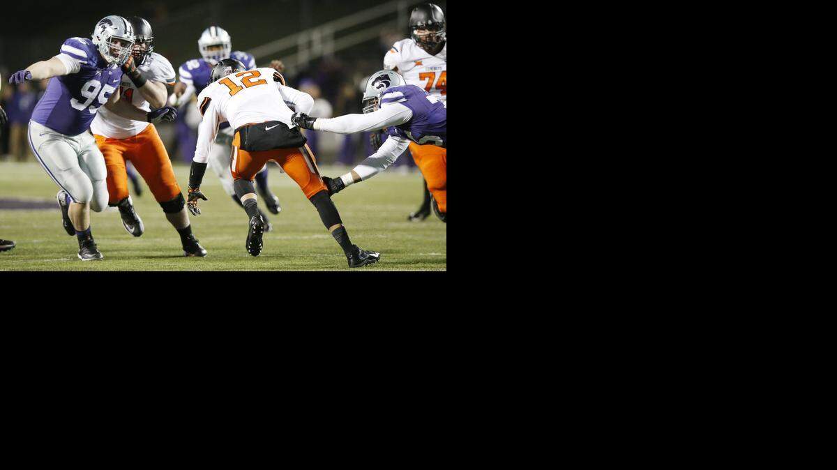 
K-State defenders Jordan Willis and Travis Britz attack Oklahoma State quarterback Daxx Garman for a sack.
