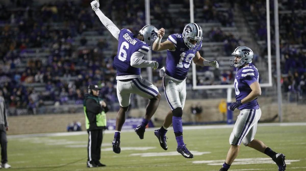 K-State players Deante Burton, left, and Kody Cook, center, celebrate late in Saturday’s victory.