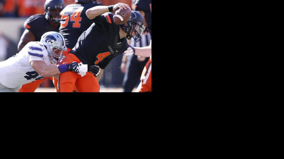 
K-State defensive end Ryan Mueller tries to bring down Oklahoma State quarterback J.W. Walsh last season in Stillwater.
