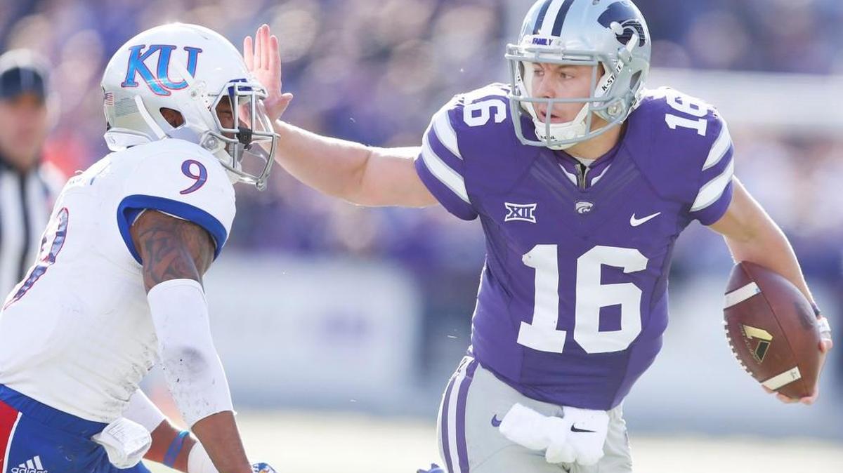 K-State quarterback Jesse Ertz pushes away Kansas safety Fish Smithson as he makes a long run Saturday in Manhattan. (November 26, 2016)