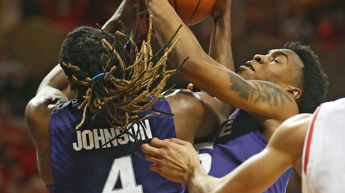 Kansas State's D.J. Johnson (4) and Wesley Iwundu (25) go for a loose ball Saturday against Texas Tech.