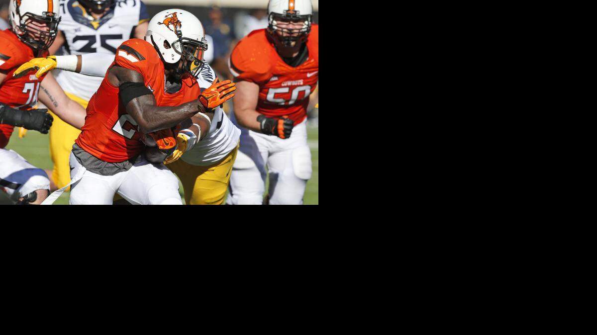 
Oklahoma State wide receiver Tyreek Hill is tackled by West Virginia defensive lineman Noble Nwachukwu. 
