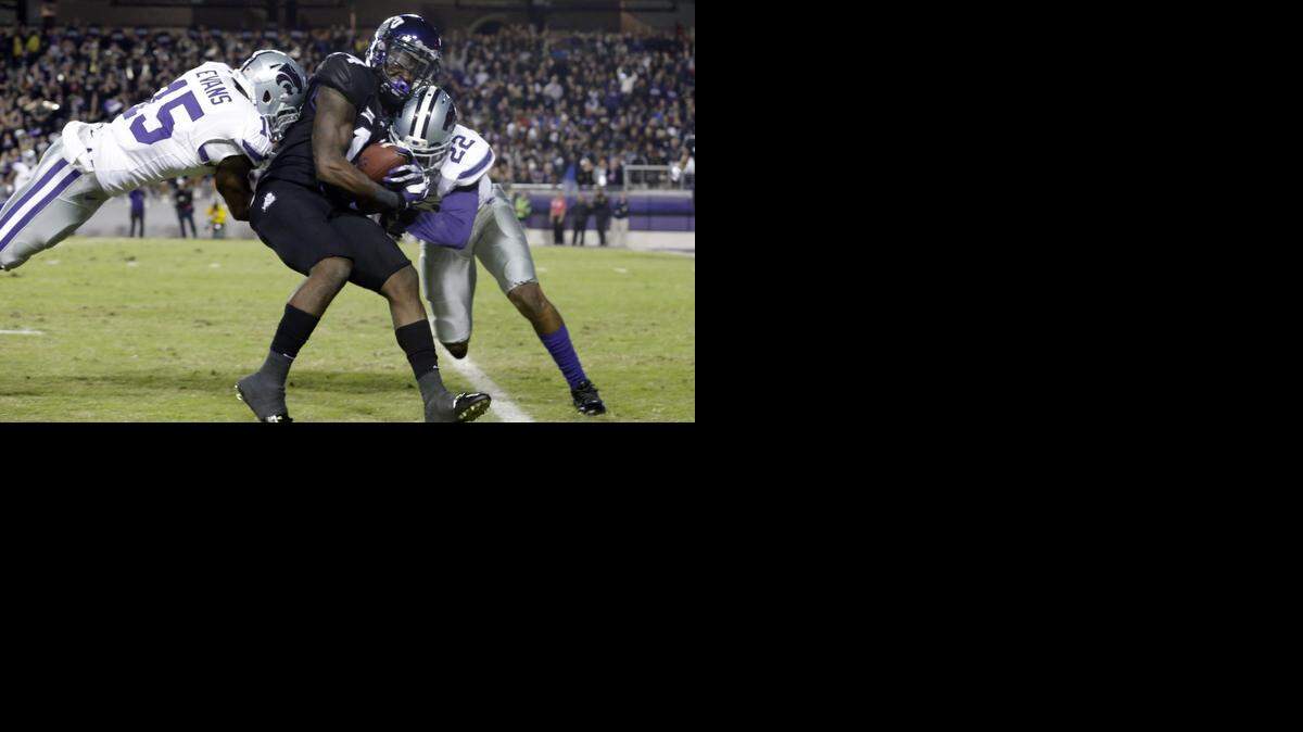 
TCU wide receiver David Porter, center, is tackled by Kansas State defensive backs Dante Barnett and Randall Evans. 
