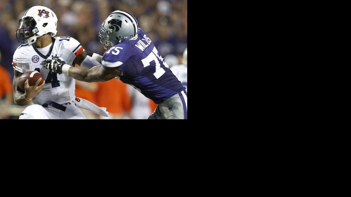 
K-State defensive end Jordan Willis can't quite get a grip of Auburn quarterback Nick Marshall.(September 18, 2014)
