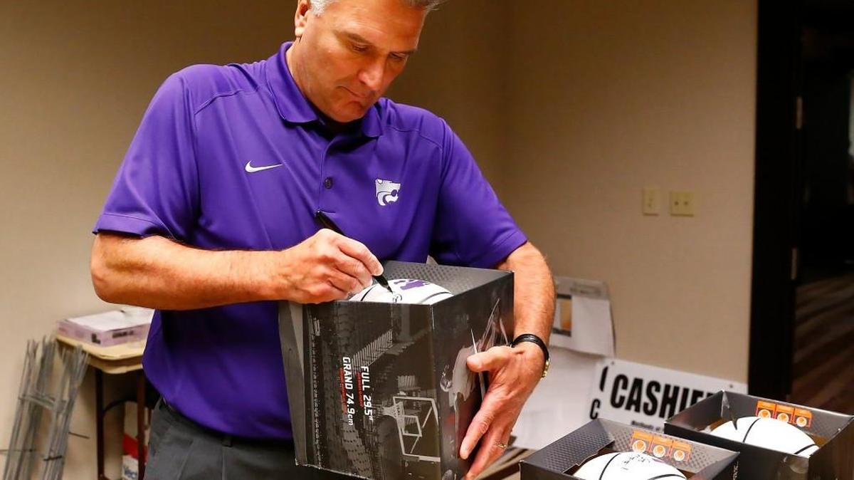 K-State basketball coach Bruce Weber autographs basketballs at the Wichita Catbackers event in Wichita's Marriott Hotel Wednesday night.