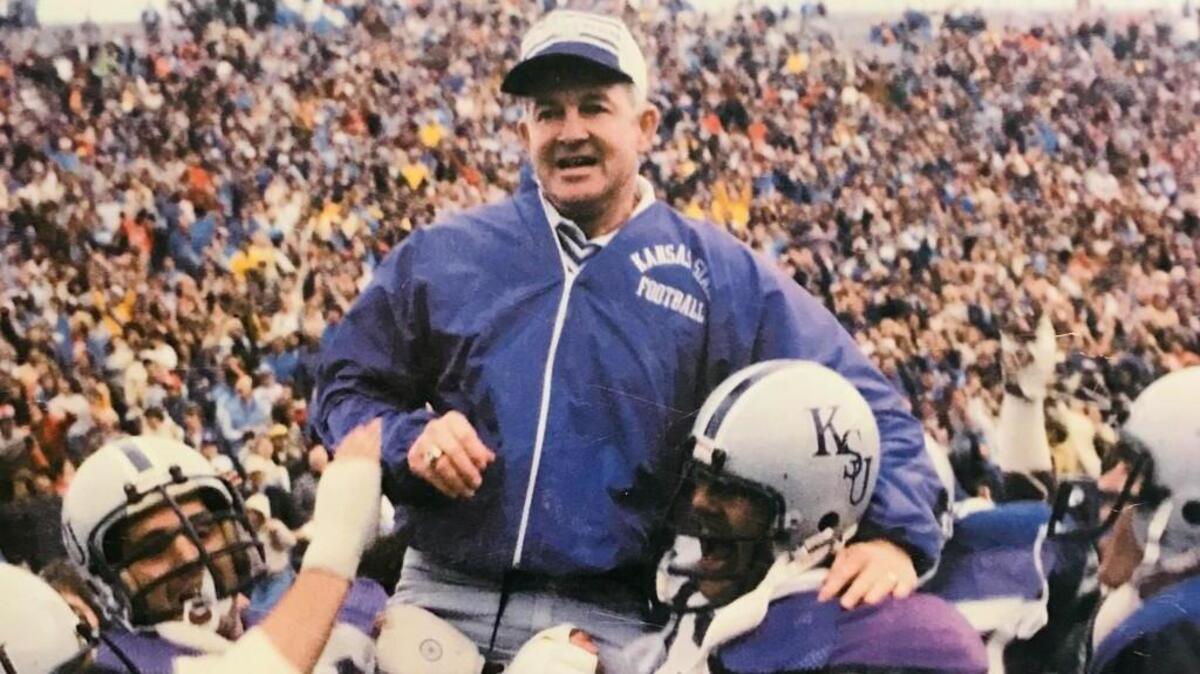 Kansas State players carry former football coach Jim Dickey off the field.