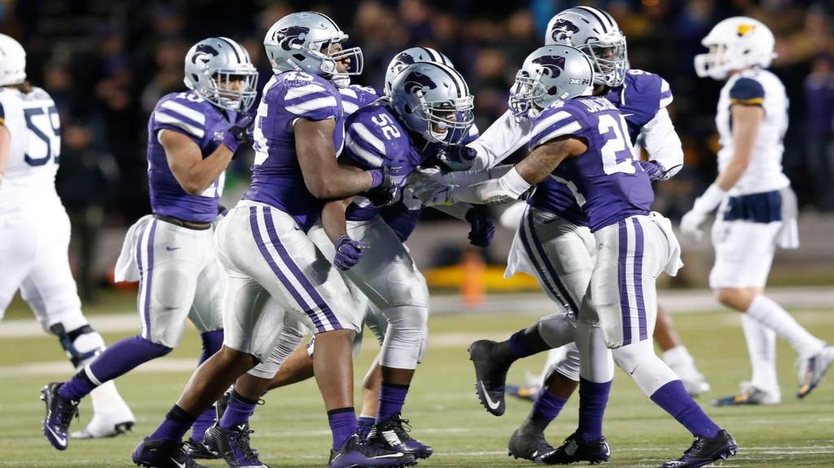 Kansas State defenders celebrate with linebacker Charmeachealle Moore (52) after a sack last season.