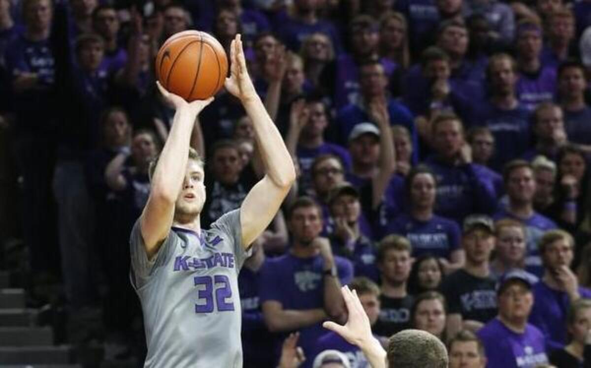 K-State forward Dean Wade (32) gets off a three-point shot in front of Kansas’ Svi Mykhailiuk late in the second half. Wade finished with 20 points.
