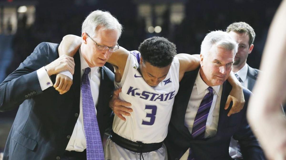 K-State guard Kamau Stokes is helped from the court by K-State head coach Bruce Weber (right) after injuring his knee Saturday during the Mississippi-K-State game. (January 30, 2016)