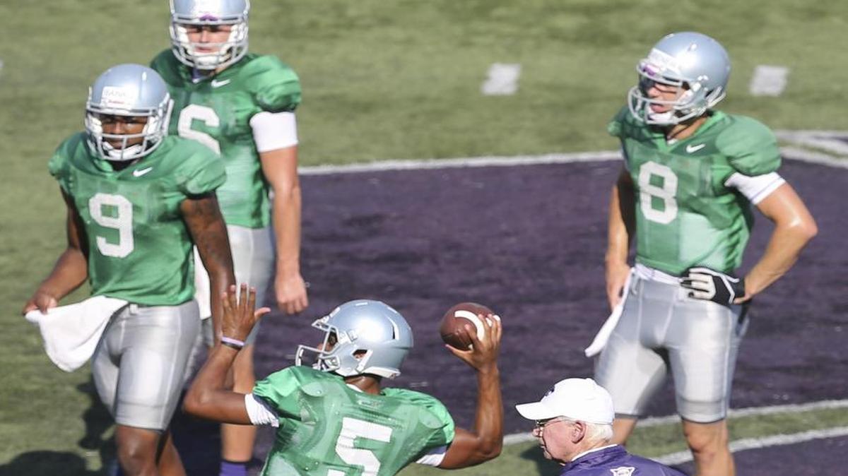 
Kansas State coach Bill Snyder watches freshman Alex Delton throw a pass while three other quarterback contenders wait their turns during the team's open practice Saturday at Snyder Family Stadium. 

