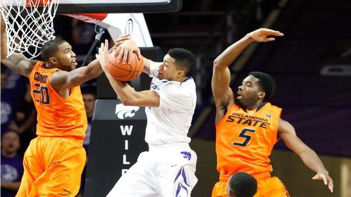 
Kansas State guard Justin Edwards grabs a rebound from Oklahoma State’s Michael Cobbins, left, and Tavarius Shine during the second half Saturday in Manhattan.
