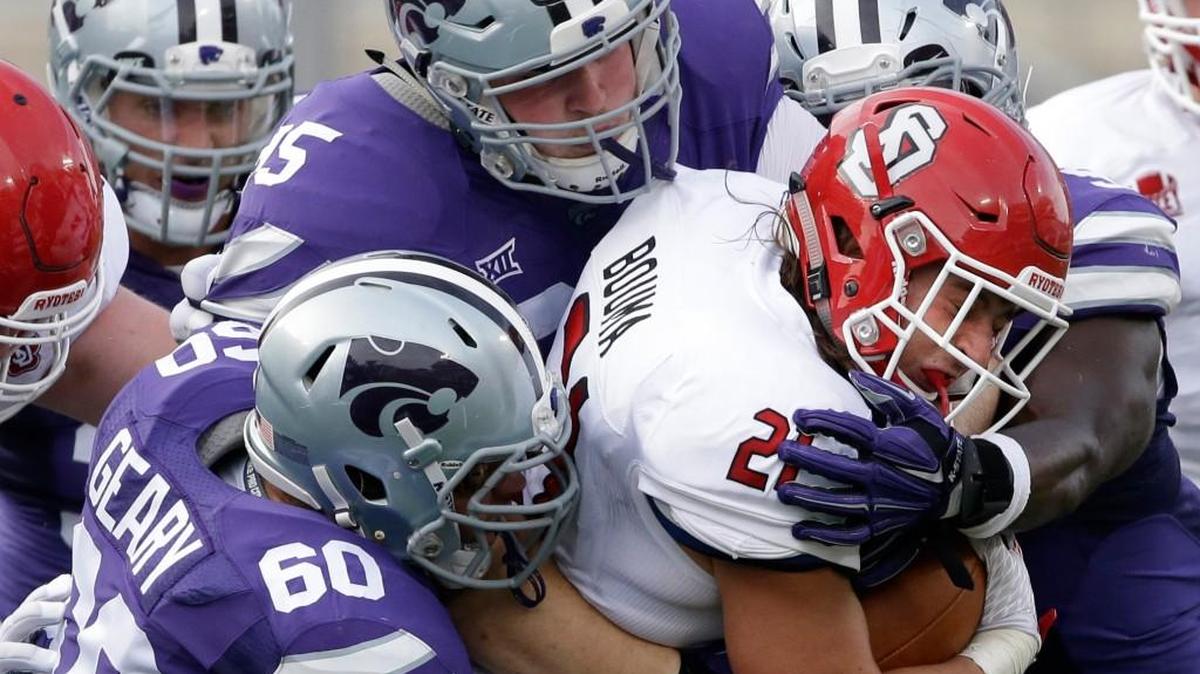 K-State defensive tackles Will Geary (60) and Travis Britz, top, tackle South Dakota’s Trevor Bouma on Sept. 5 in Manhattan.