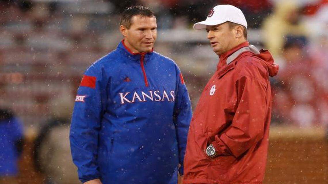 
Kansas coach Clint Bowen, left, and Oklahoma coach Bob Stoops talk before the start of Saturday’s game in Norman, Okla.
