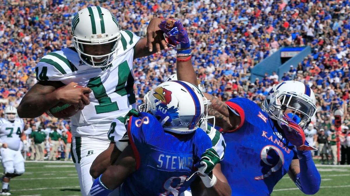 Ohio quarterback Greg Windham (14) scores a touchdown over Kansas cornerback Brandon Stewart (8) and safety Fish Smithson during the first half Saturday in Lawrence.