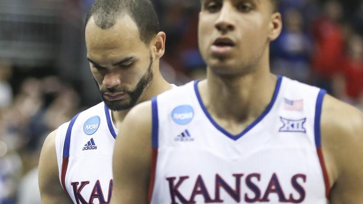 Perry Ellis, behind teammate Landen Lucas, walks off the court for the last time as a Jayhawk after Kansas lost 64-59 to Villanova on Saturday in Louisville, Ky. Ellis had a season-low four points.