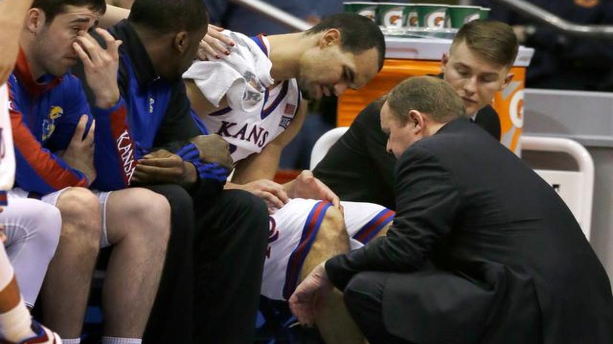 
A member of Kansas’ training staff checks Perry Ellis on the bench during the first half of Tuesday at Allen Fieldhouse in Lawrence. Ellis did not play in the second half.
