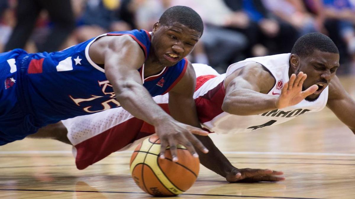 
Kansas forward Carlton Bragg, Jr., left, and Team Canada guard Jarred Ogunbemi-Jackson dive for a loose ball during an exhibition game Tuesday at Sprint Center in Kansas City, Mo. 
