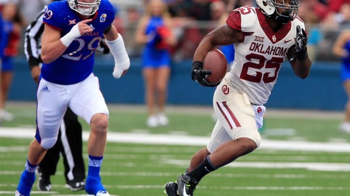 Oklahoma running back Joe Mixon (25) runs away from Kansas linebacker Joe Dineen Jr. (29) for a touchdown Saturday.