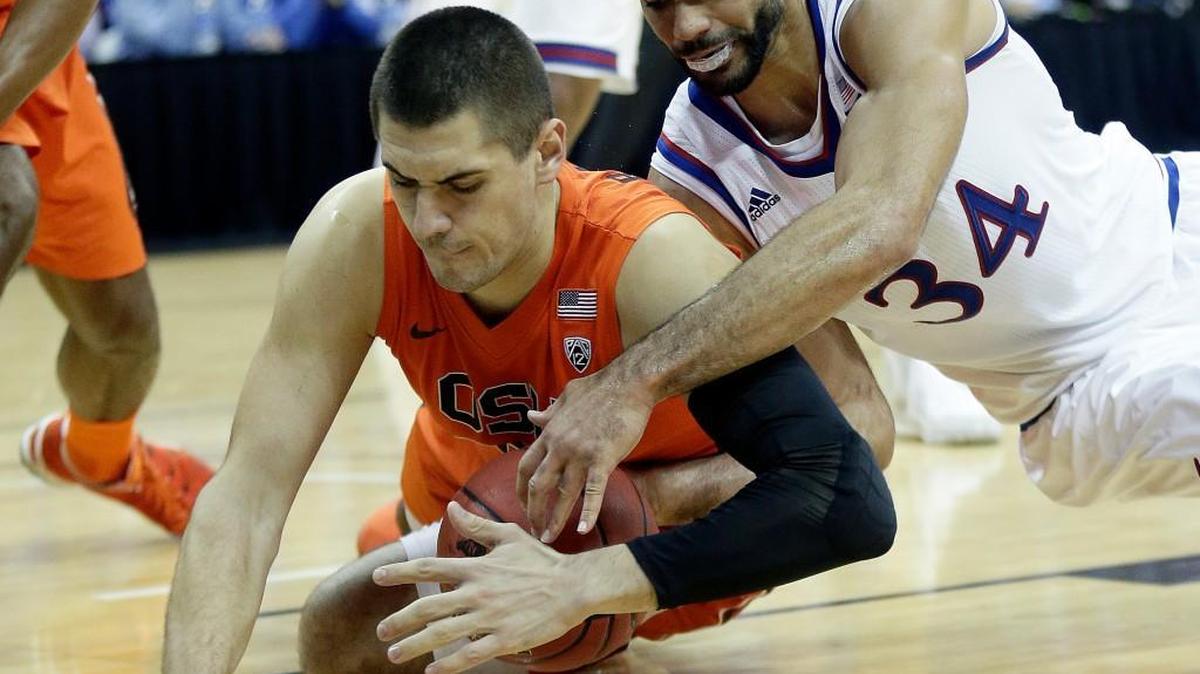 Oregon State's Gligorije Rakocevic, left, and Kansas' Perry Ellischase a loose ball during the first half Saturday at Sprint Center in Kansas City, Mo.