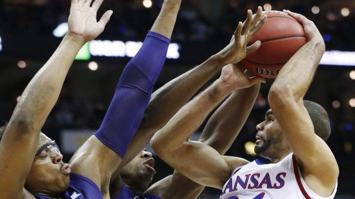 Kansas forward Perry Ellis, right, goes up against K-State’s Stephen Hurt, left, and D.J. Johnson during the quarterfinals of the Big 12 Tournament at the Sprint Center.