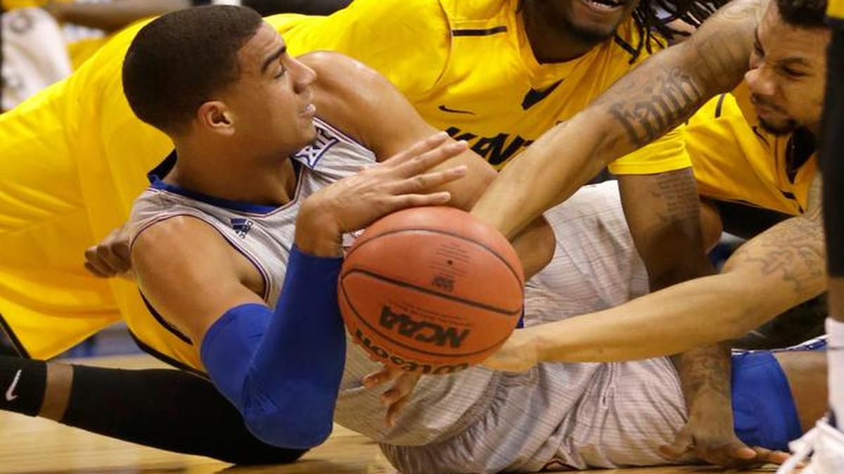 
Kansas forward Landen Lucas hits the floor with Kent State’s Marquiez Lawrence, back, and Devareaux Manley, right, during the first half Tuesday night in Lawrence.

