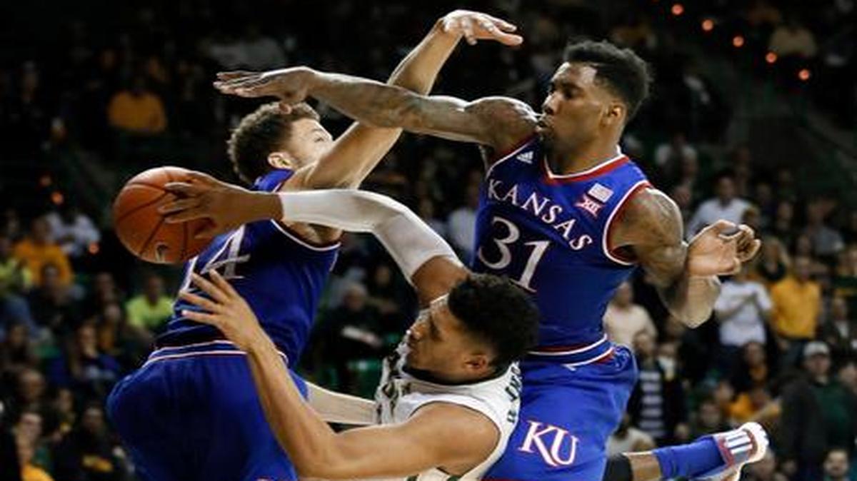 
Baylor’s Ishmail Wainright tries to pass the ball between Kansas's Brannen Greene, left, and Jamari Traylor during the second half Wednesday in Waco, Texas. Wainright was fouled on the play.

