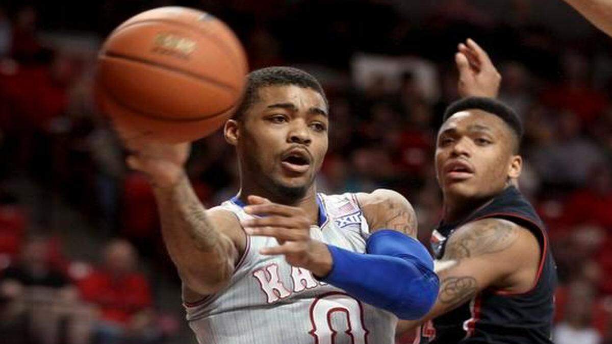 
Kansas’ Frank Mason passes in front of Texas Tech's Robert Turner on Tuesday night in Lubbock, Texas.
