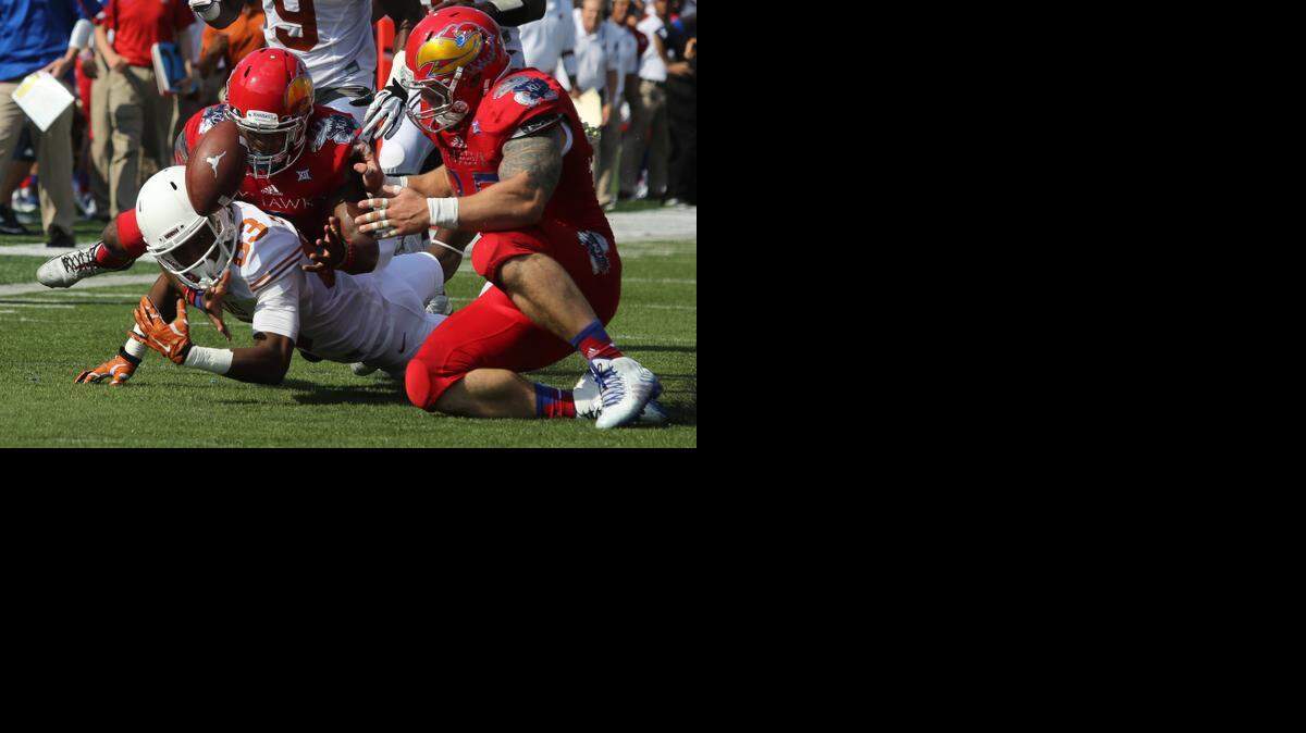 
Texas’ Armanti Foreman (83) fumbles the ball as he is hit by Kansas’ Isaiah Johnson, back, and T.J. Semke in the first quarter.

