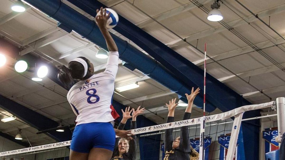 Kansas’ Kelsie Payne spikes over Missouri’s Emily Thater on left and Regan Peltier during Friday’s match in Lawrence.