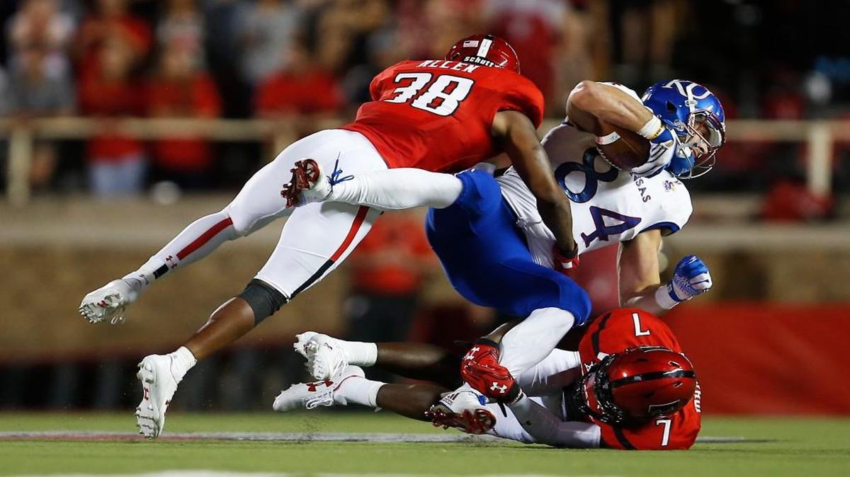 Texas Tech's Kisean Allen (38) and Jah'Shawn Johnson tackle Kansas’ Ben Johnson during Thursday’s game in Lubbock, Texas.