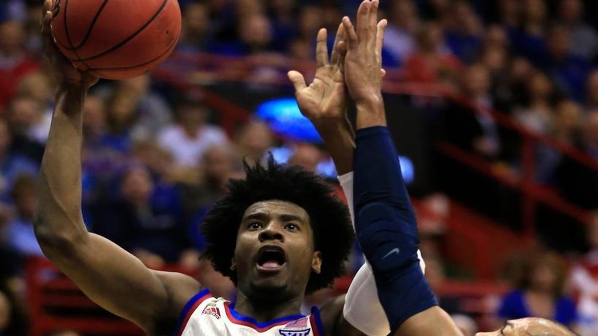 Kansas guard Josh Jackson (11) shoots while covered by West Virginia guard Jevon Carter during the first half.