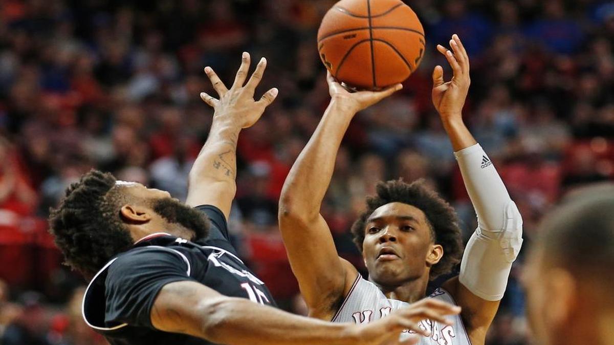 Devonte' Graham shoots over Texas Tech's Aaron Ross on Saturday in Lubbock.