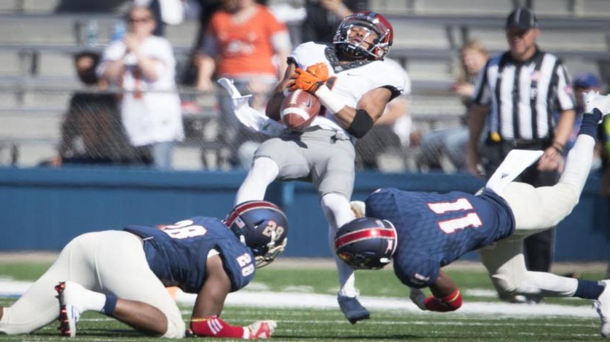 Oklahoma State Cowboys wide receiver Jalen McCleskey hangs onto the ball as he is tackled by Kansas’ Courtney Arnick, left, and Mike Lee in the first quarter Saturday in Lawrence.