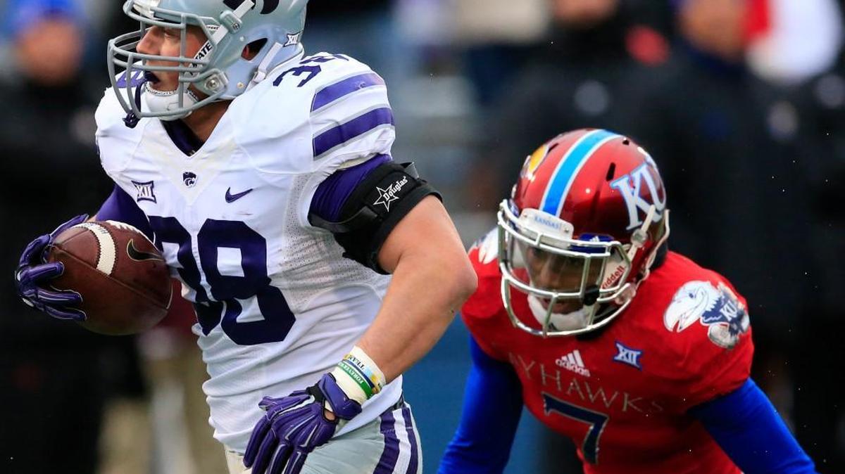 Kansas State fullback Winston Dimel (38) gains 44 yards before being tackled by Kansas defender Derrick Neal in Saturday’s first half.