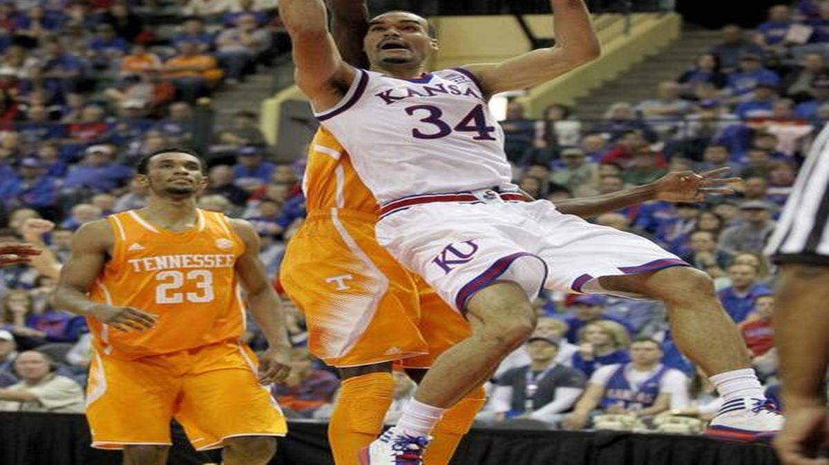 
Kansas forward Perry Ellis (34) shoots in front of Tennessee forward Willie Carmichael III and forward Derek Reese (23) during the first half Friday in Lake Buena Vista, Fla.
