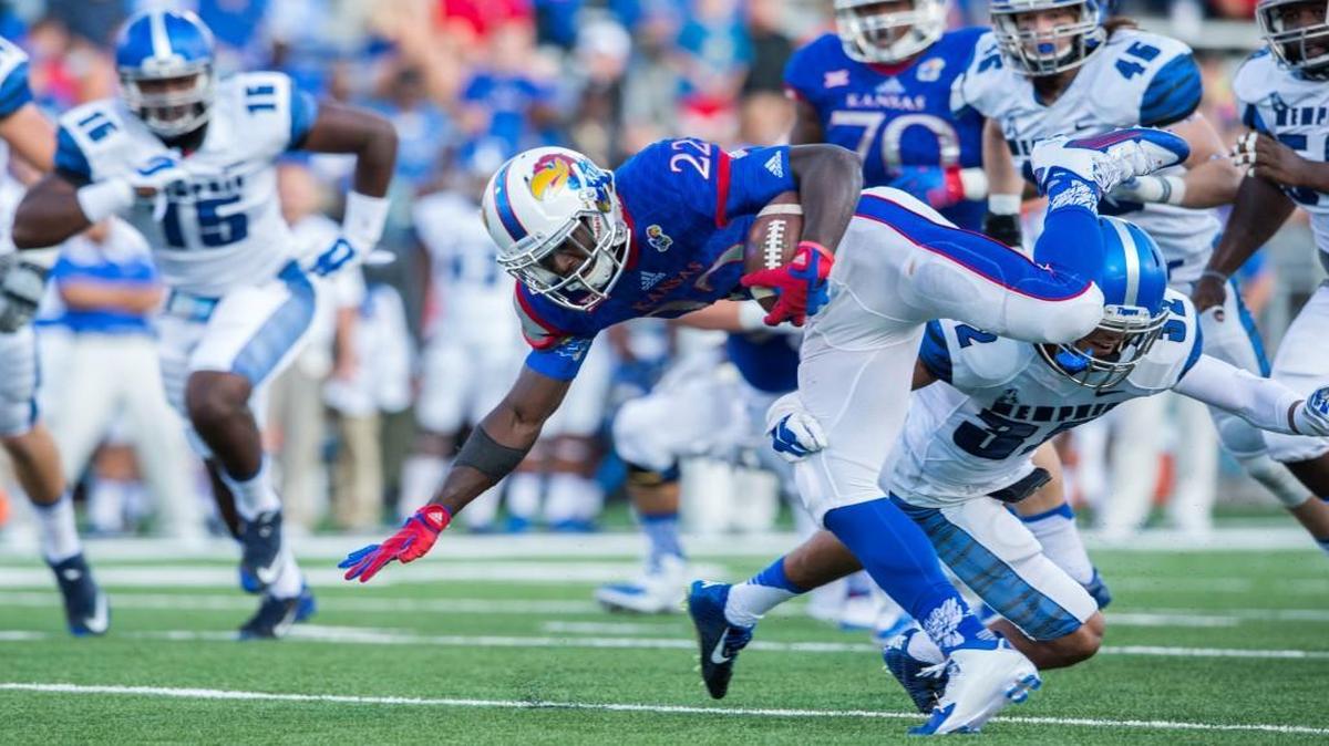 
Kansas running back Ke’aun Kinner manages to keep his feet and gain more yards after Memphis defensive back DaShaughn Terry (32) tried to tackle him in the first quarter Saturday in Lawrence. 
