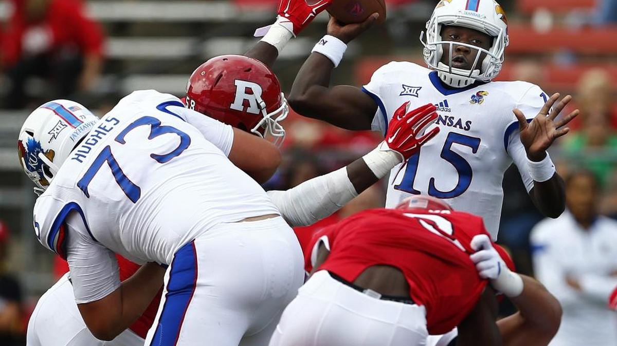 
Kansas quarterback Deondre Ford (15) throws under pressure against Rutgers during the first quarter Saturday.
