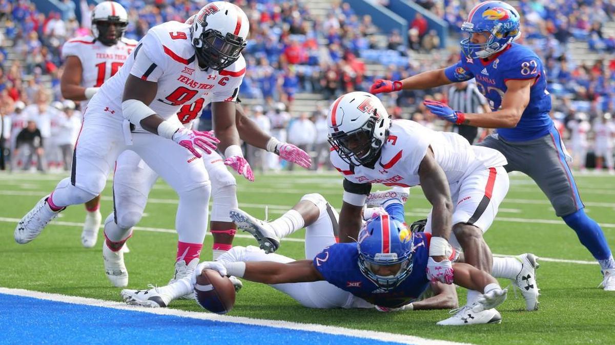 
Kansas wide receiver Darious Crawley put the ball across the goal line for a touchdown as he was defended by Texas Tech defensive back J.J. Gaines (3) and defensive lineman Branden Jackson (9) in the second half Saturday at Memorial Stadium in Lawrence. 
