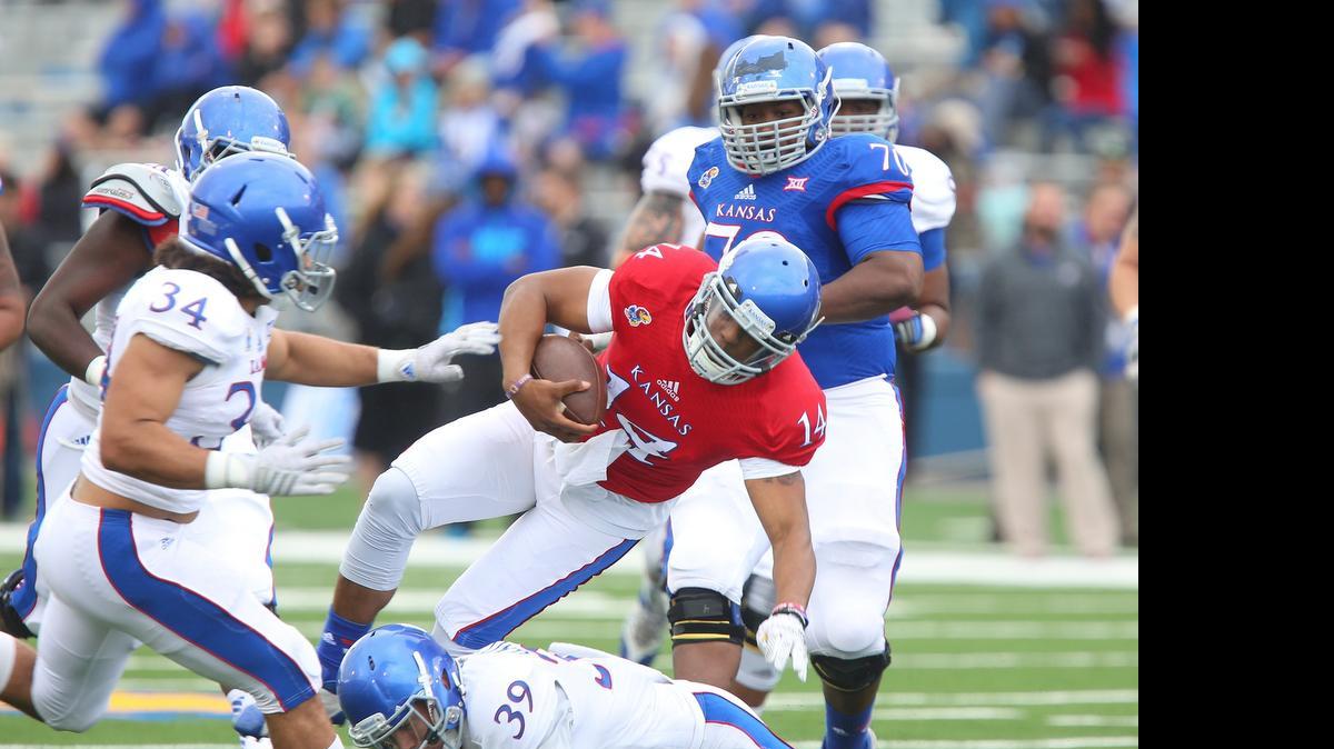 
Kansas quarterback Michael Cummings (14) is injured during a tackle by safety Michael Glatczak (39) on a run during Saturday’s spring game in Lawrence.
