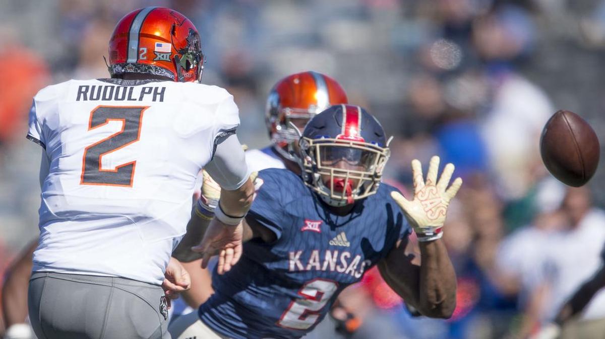 Oklahoma State Cowboys quarterback Mason Rudolph (2) got rid of the ball before Kansas Jayhawks defensive end Dorance Armstrong Jr. (2) could make a sack during the Univeristy of Kansas and Oklahoma State University Big 12 football game at Memorial Stadium on Saturday, October 22, 2016, in Lawrence, Kansas.
