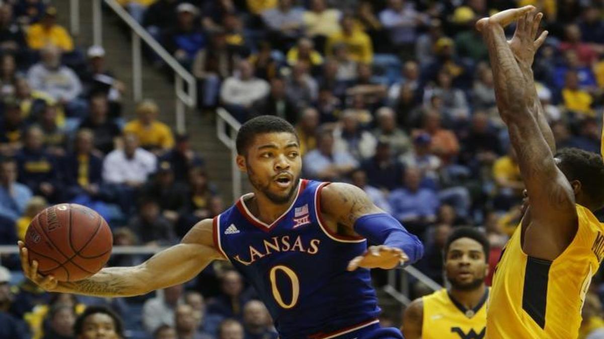 Kansas guard Frank Mason looks to pass while being guarded by West Virginia’s Daxter Miles during the first half Tuesday in Morgantown, W.Va.