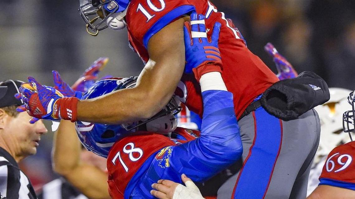 Kansas offensive lineman Hakeem Adeniji picks up his teammate Khalil Herbert (10) after Herbert scored a touchdown against Texas at Memorial Stadium last fall in Lawrence.