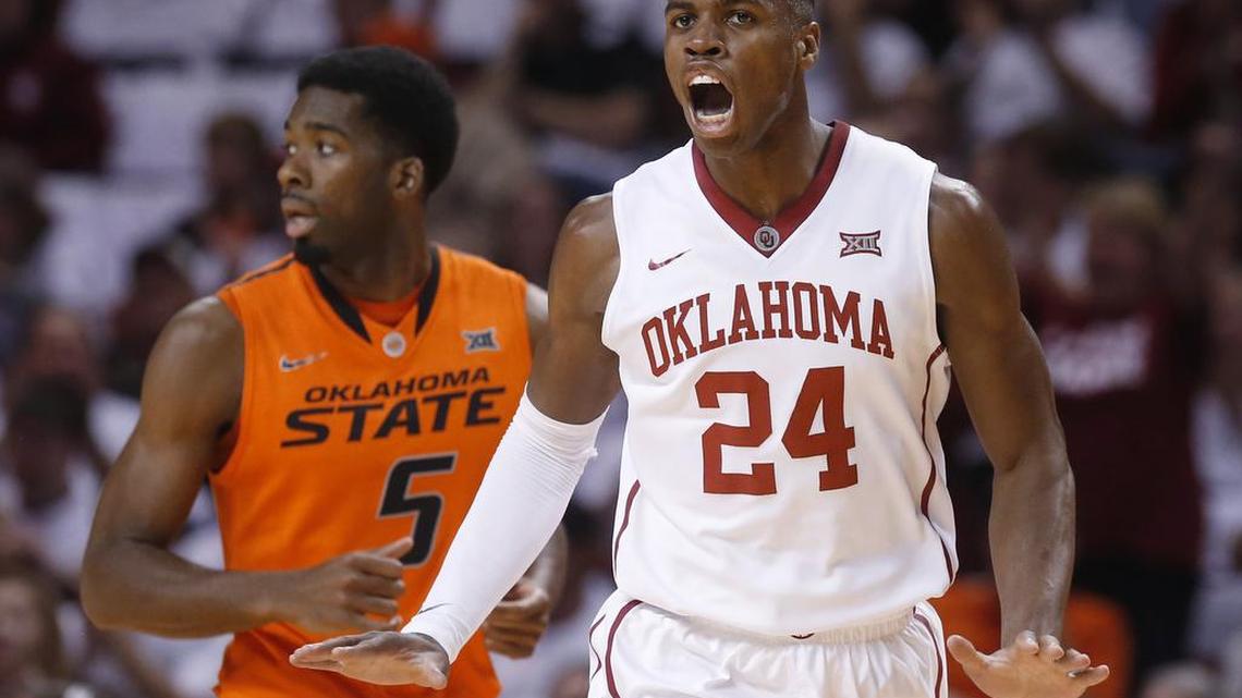 Oklahoma guard Buddy Hield (24) celebrates a basket in front of Oklahoma State guard Tavarius Shine (5) during the first half of a game on Jan. 17, 2015, in Norman, Okla.
