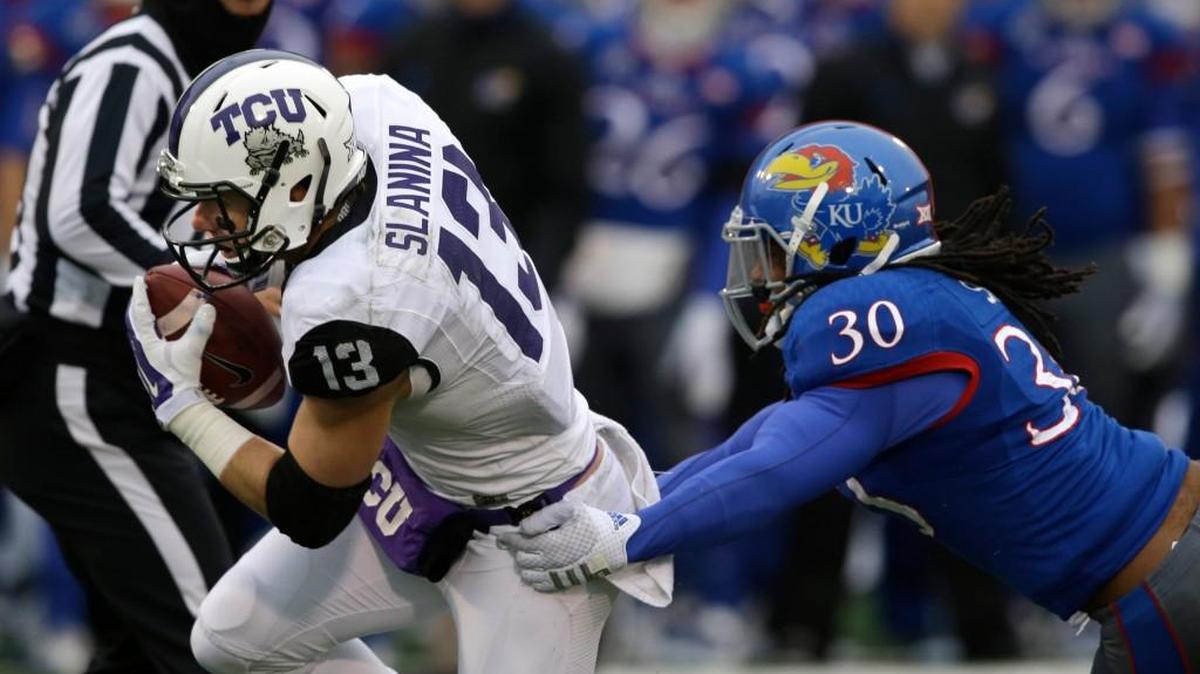 
Kansas safety Tevin Shaw (30) tries to tackle TCU wide receiver Ty Slanina last season.
