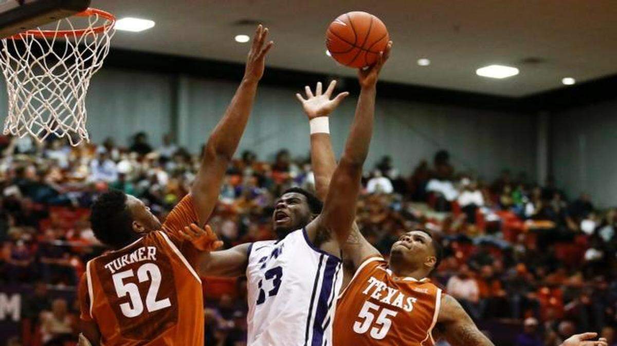 
Texas’ Myles Turner, left, and Cameron Ridley defend a shot by TCU’s Chris Washburn during Monday’s game in Fort Worth.
